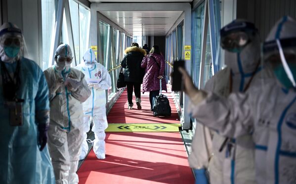 Nhân viên y tế mặc đồ bảo hộ trên ống lồng hành lang hành khách ở sân bay thủ đô Bắc Kinh - Sputnik Việt Nam