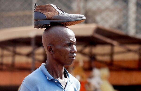 Người đàn ông với chiếc giày trên đầu tại chợ Mvog Ada ở Yaounde, thủ đô Cameroon - Sputnik Việt Nam