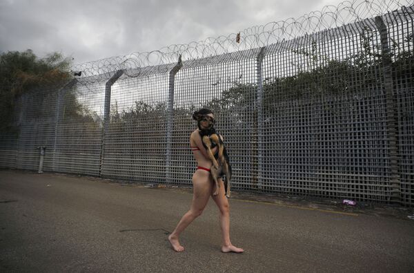 Phụ nữ Israel bế con chó của mình khi vượt qua hàng rào biên giới với Jordan sau khi ngâm mình trong hồ bơi suối nước nóng ở Cao nguyên Golan - Sputnik Việt Nam
