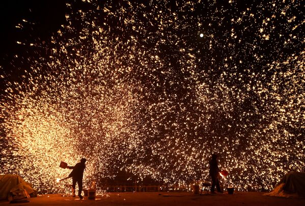 Những người thợ rèn tạo ra cơn mưa tia lửa từ kim loại nóng chảy trước khi diễn ra Lễ hội đèn lồng ở công viên Bắc Kinh - Sputnik Việt Nam