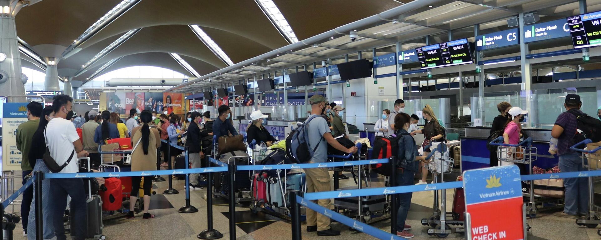 Hành khách làm thủ tục ngày 17/2/2022 tại sân bay quốc tế Kuala Lumpur, Malaysia để lên chuyến bay VN674. - Sputnik Việt Nam, 1920, 15.03.2022