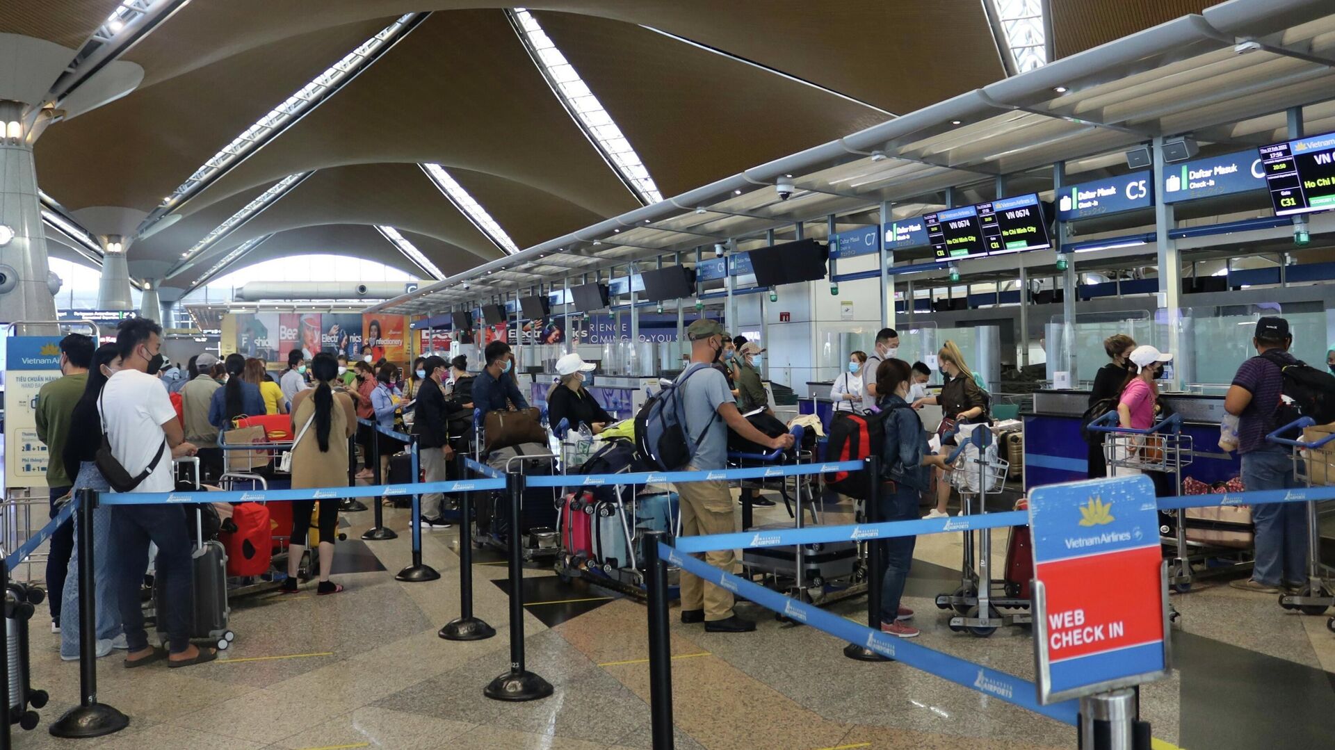 Hành khách làm thủ tục ngày 17/2/2022 tại sân bay quốc tế Kuala Lumpur, Malaysia để lên chuyến bay VN674. - Sputnik Việt Nam, 1920, 19.03.2022