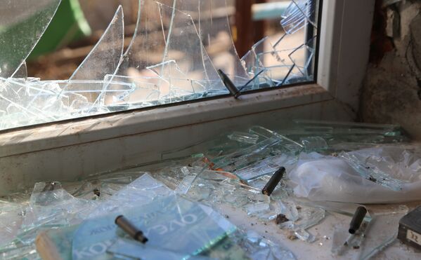 Cửa sổ vỡ và vỏ đạn trên bệ cửa sổ trong tòa nhà dân ở khu vực Kiev, Donetsk, vào đêm 20/2, nhóm phá hoại Ukraina đã bị tiêu diệt - Sputnik Việt Nam