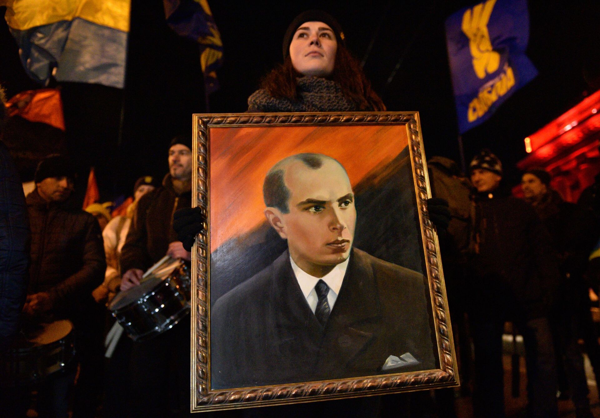 Một người tham gia lễ rước những người theo chủ nghĩa dân tộc ở Kiev với bức chân dung của Bandera, 2019 - Sputnik Việt Nam, 1920, 26.02.2022