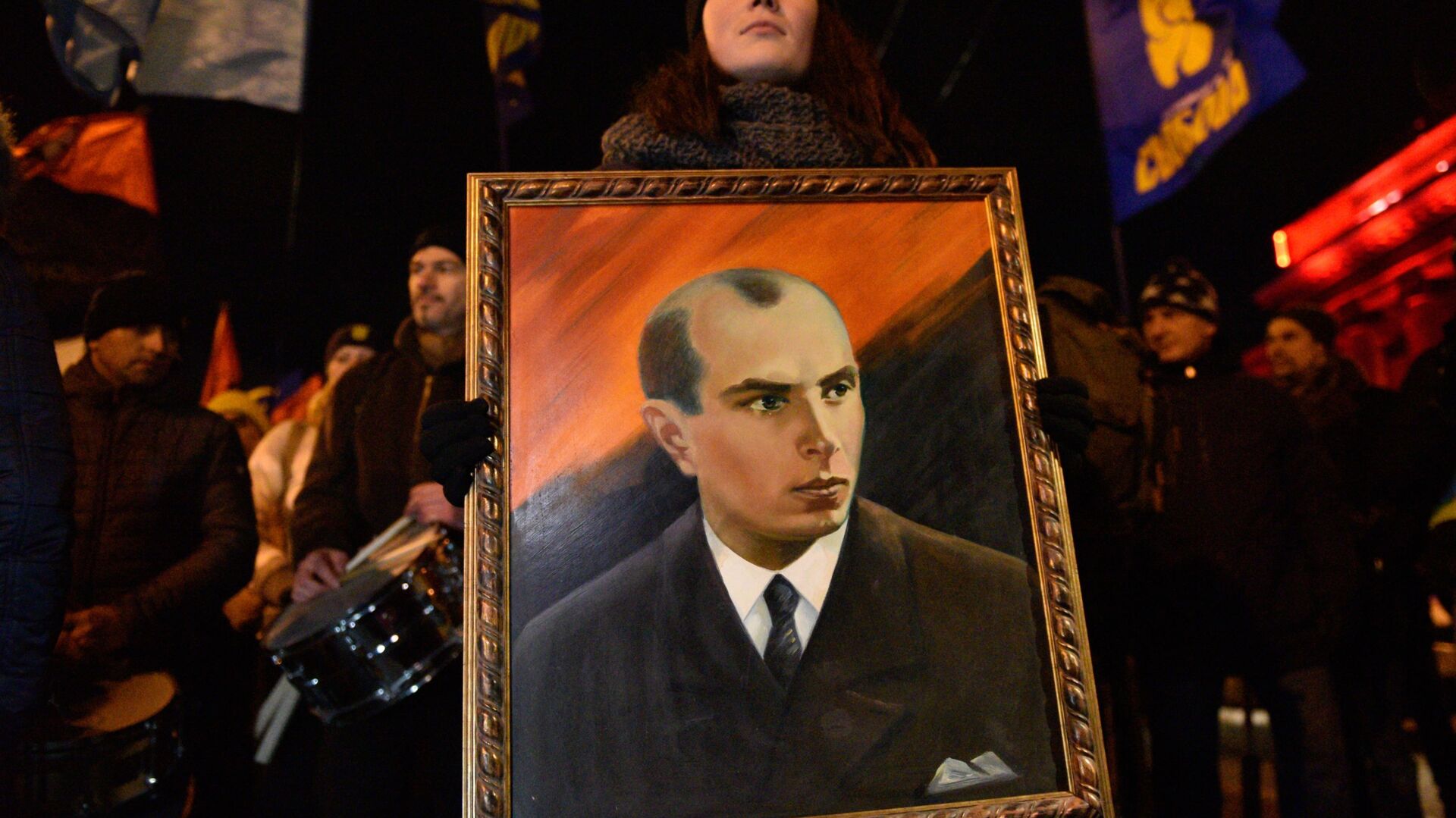 Một người tham gia lễ rước những người theo chủ nghĩa dân tộc ở Kiev với bức chân dung của Bandera, 2019 - Sputnik Việt Nam, 1920, 19.06.2022