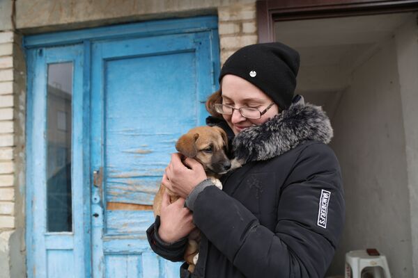 Người phụ nữ ôm con chó con trên tay ở làng Nikolaevka, Cộng hòa Nhân dân Donetsk - Sputnik Việt Nam