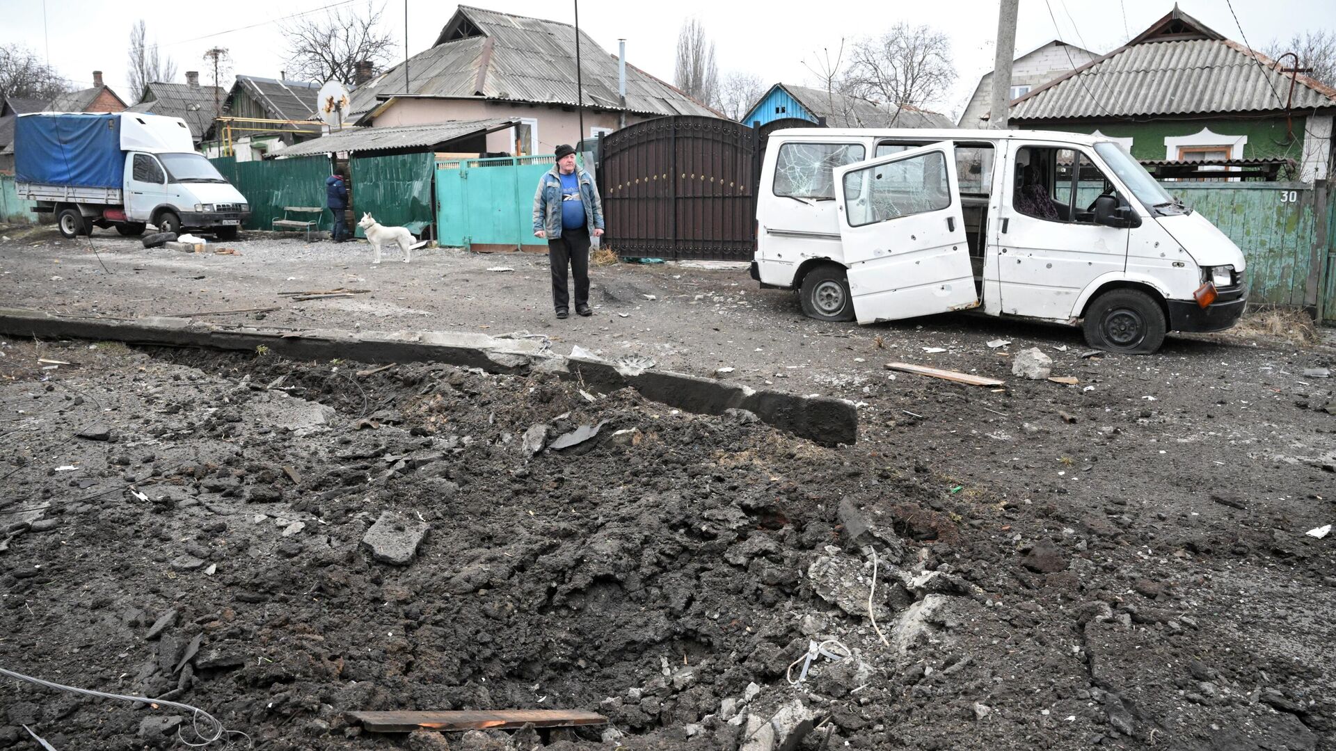 Hố đạn và chiếc ô tô bị hư hại do pháo kích ở quận Kievsky của Donetsk. - Sputnik Việt Nam, 1920, 05.03.2022