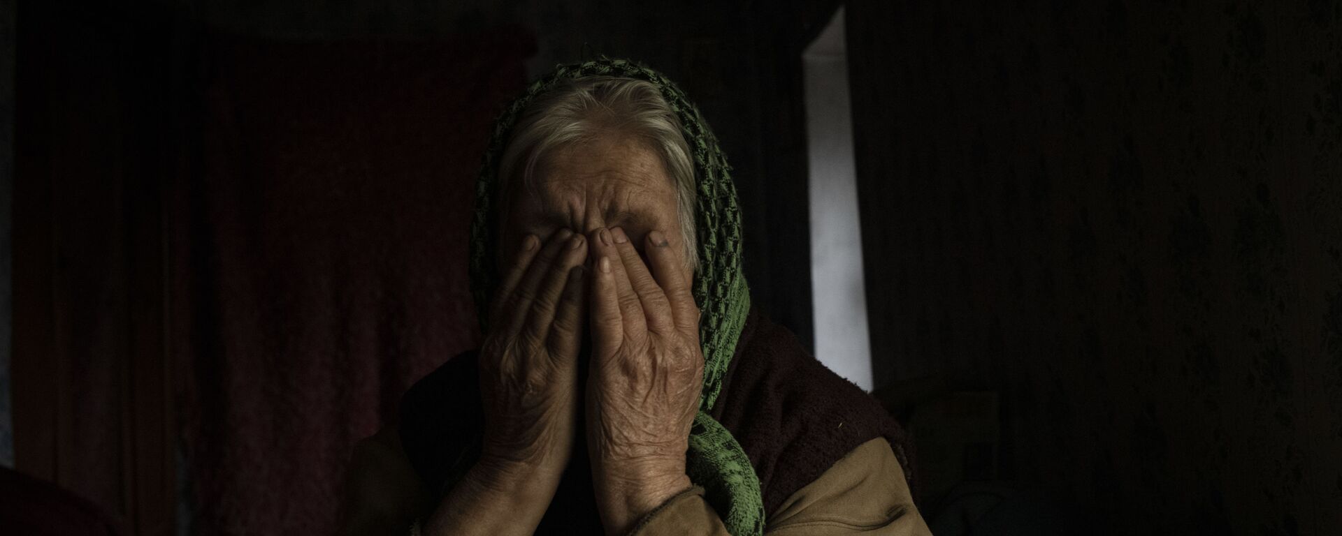 Một người phụ nữ lớn tuổi khóc trong ngôi nhà của mình ở làng Trekhizbenka, Cộng hòa Nhân dân Luhansk - Sputnik Việt Nam, 1920, 07.03.2022