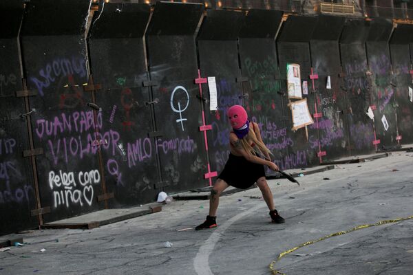 Người phụ nữ ném rác vào hàng rào trong cuộc biểu tình nhân Ngày Quốc tế Phụ nữ ở Mexico City, Mexico - Sputnik Việt Nam