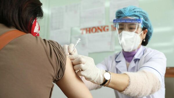 Nhân viên y tế tiêm vaccine phòng COVID-19 cho người dân phường Lê Đại Hành (quận Hai Bà Trưng). - Sputnik Việt Nam