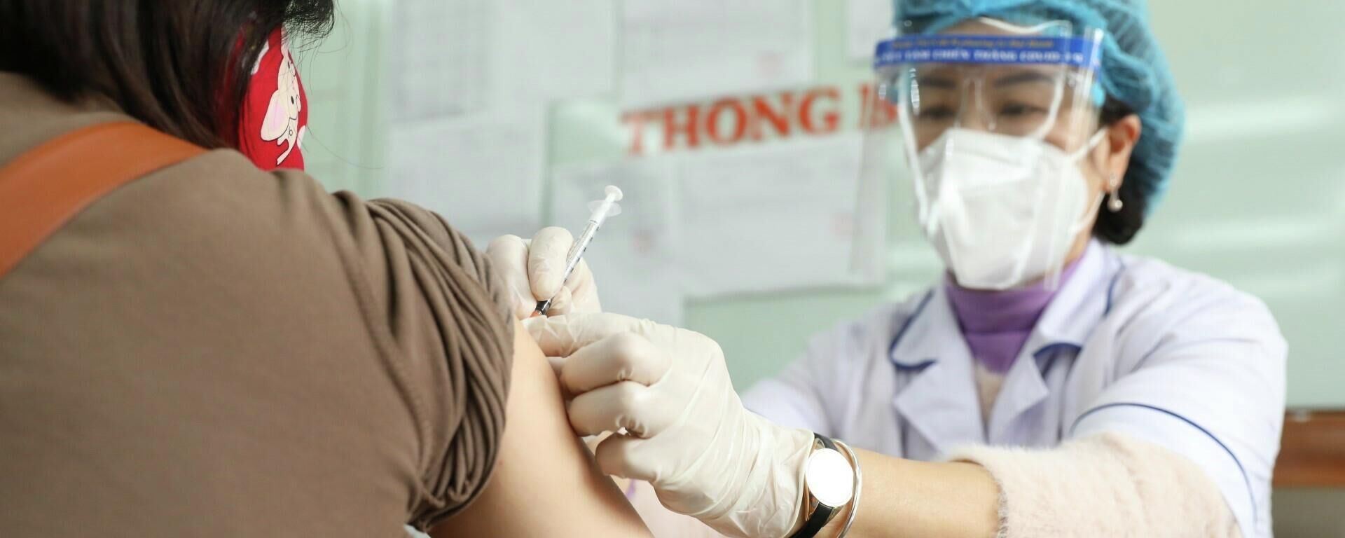 Nhân viên y tế tiêm vaccine phòng COVID-19 cho người dân phường Lê Đại Hành (quận Hai Bà Trưng). - Sputnik Việt Nam, 1920, 19.03.2022