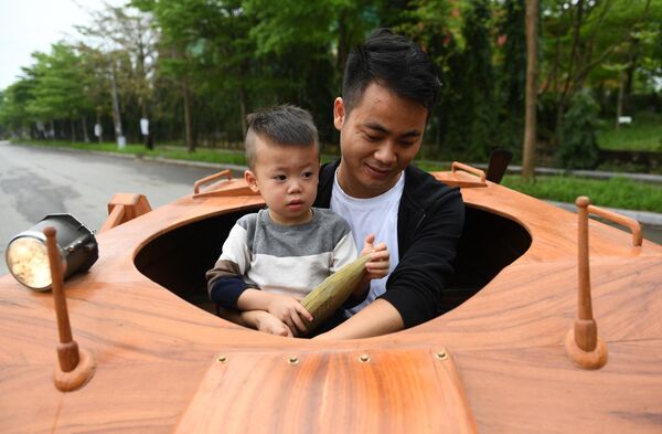 Trương Văn Đạo bên con trai trên chiếc xe tăng gỗ ở Bắc Ninh - Sputnik Việt Nam