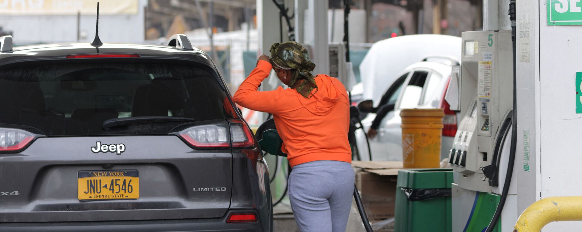 Một người phụ nữ đổ xăng trên ô tô tại một trạm xăng ở Manhattan, New York - Sputnik Việt Nam, 1920, 30.03.2022