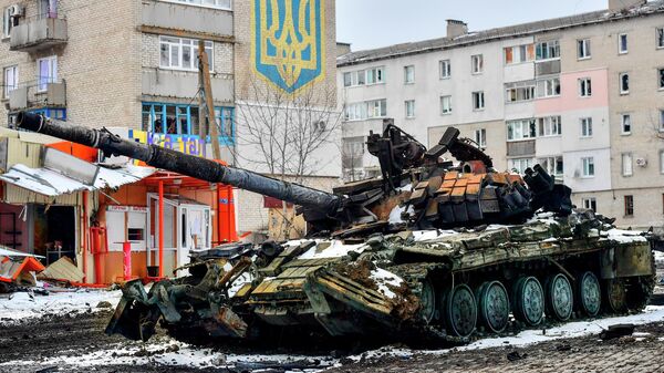 Xe tăng bị phá hủy của Lực lượng vũ trang Ukraine gần ngôi nhà có quốc huy Ukraine ở Volnovakha - Sputnik Việt Nam