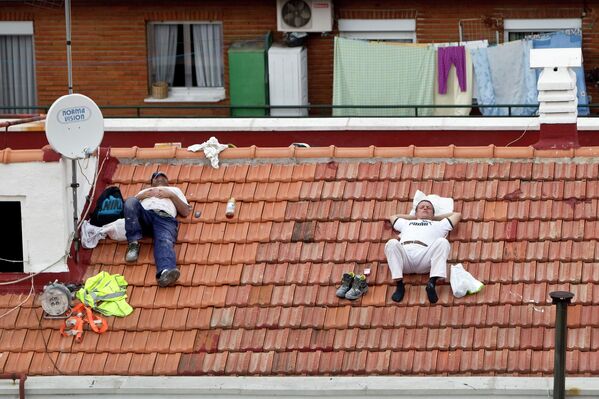 Giấc ngủ trưa lành mạnh là công thức kéo dài tuổi thọ của người dân Tây Ban Nha. Ảnh: Hai người công nhân ngủ trưa trên sân thượng ở Madrid, Tây Ban Nha - Sputnik Việt Nam