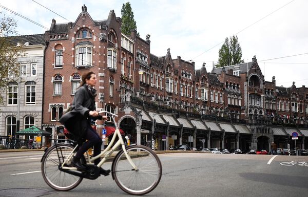 Tại Hà Lan, dân chúng thích đi lại bằng xe đạp, điều này giúp họ giữ gìn sức khỏe.Ảnh: Cô gái đạp xe trên đường phố Amsterdam - Sputnik Việt Nam