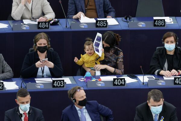 Nữ nghị sĩ Slovenia Irena Joveva (giữa) bế đứa trẻ tại Nghị viện châu Âu - Sputnik Việt Nam