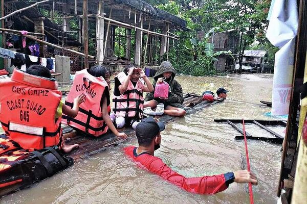 Lực lượng cứu hộ sơ tán cư dân khỏi ngôi làng bị ngập lụt ở Panitan, Philippines - Sputnik Việt Nam