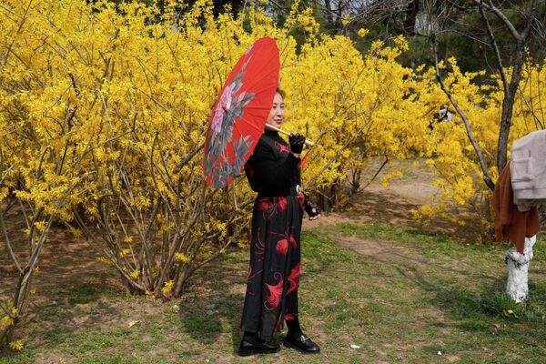 Người phụ nữ tạo dáng bên hoa trong công viên Bắc Kinh - Sputnik Việt Nam