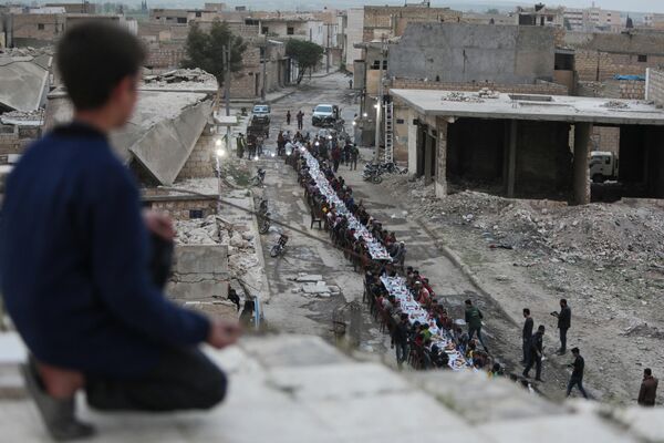 Những người Syria ngồi quanh bàn trong bữa tối iftar sau tuần chay gần thị trấn biên giới al-Bab - Sputnik Việt Nam
