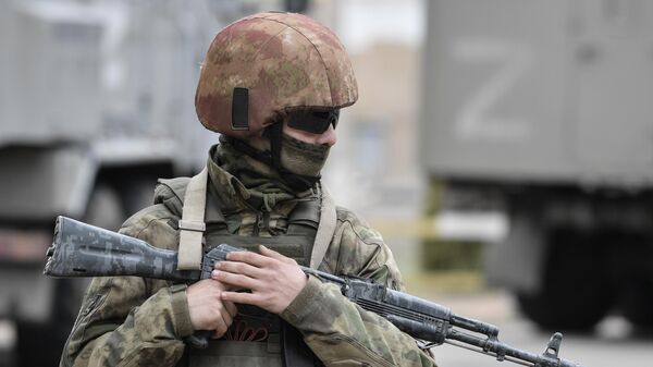 Một binh sĩ thuộc Lực lượng Vệ binh Quốc gia Nga tuần tra khu vực khi hoạt động quân sự của Nga ở Ukraine tiếp tục, ở Kherson, Ukraina - Sputnik Việt Nam