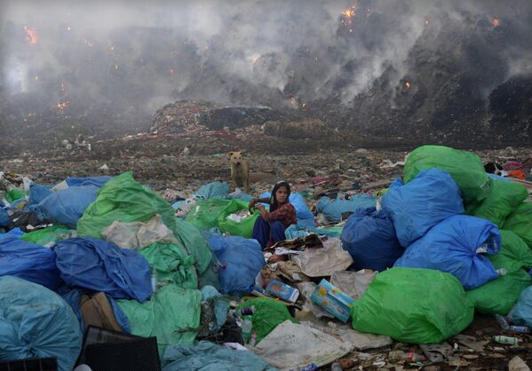 Bà đồng bát lựa chọn đồ trong đám cháy tại bãi rác Bhalswa ở New Delhi, Ấn Độ. - Sputnik Việt Nam