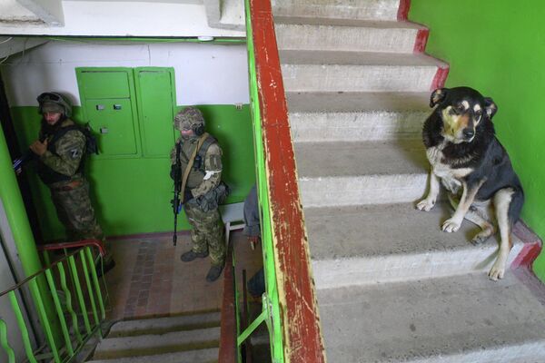 Các quân nhân Nga tại lối vào tòa nhà dân cư ở thành phố Rubizhne, Cộng hòa Nhân dân Lugansk. - Sputnik Việt Nam