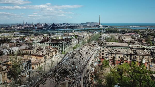 Các tòa nhà bị phá hủy ở trung tâm Mariupol. Ở hậu cảnh là nhà máy luyện kim Azovstal. - Sputnik Việt Nam