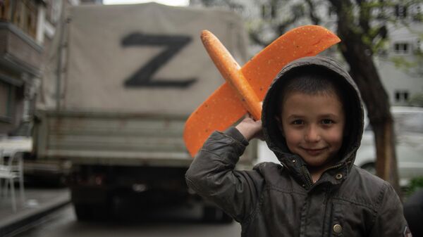 Một cậu bé với chiếc máy bay đồ chơi trên đường phố ở Mariupol - Sputnik Việt Nam