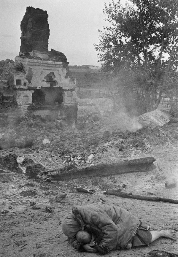 Người mẹ che chắn cho con nhỏ trong trận pháo kích. Làng Krasnaya Sloboda, Mặt trận Bryansk, năm 1941. - Sputnik Việt Nam