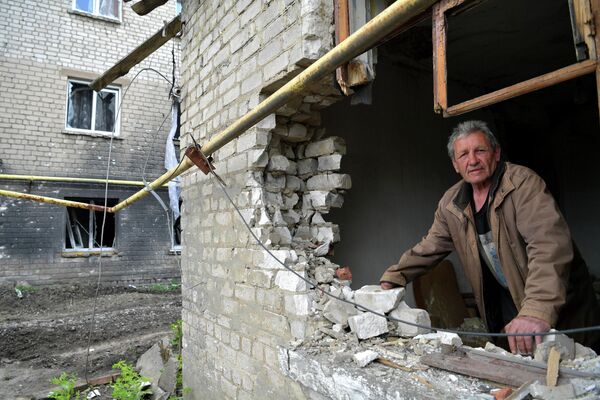 Một người đàn ông trong ngôi nhà bị phá hủy của mình ở thị trấn Popasna - Sputnik Việt Nam
