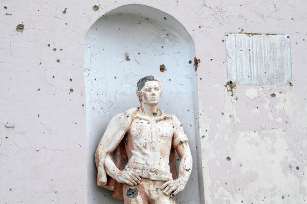 Một bức tượng bị pháo kích làm hư hại tại nhà ga xe lửa ở thị trấn Popasna - Sputnik Việt Nam