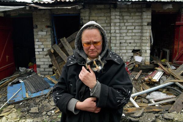Một người phụ nữ với con mèo trong khu vực tư nhân bị phá hủy của thị trấn Popasna - Sputnik Việt Nam