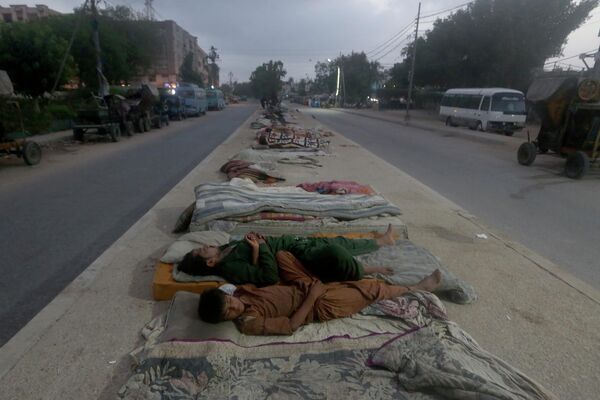 Những người thợ ngủ giữa đường trong sáng sớm mùa hè nóng nực ở Karachi, Pakistan - Sputnik Việt Nam