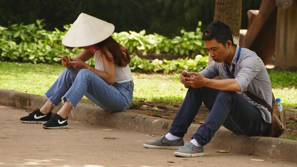 Người Việt Nam cầm điện thoại trên đường phố - Sputnik Việt Nam
