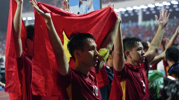 Các cầu thủ Việt Nam ăn mừng chiến thắng trên bục cùng người hâm mộ tại chung kết bóng đá nam SEA Games 31 (Đội trưởng Hùng Dũng và thủ môn Văn Toản) - Sputnik Việt Nam