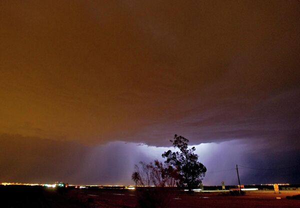 Tia chớp được nhìn thấy qua một cơn bão bụi trên bầu trời thành phố Gilbert, Arizona của Mỹ. - Sputnik Việt Nam