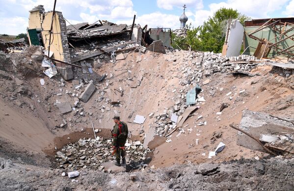 Hố bom sau cuộc không kích của Lực lượng vũ trang Ukraina ở làng Yatskovka. - Sputnik Việt Nam