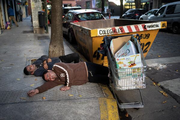 Những người nghỉ ngơi trên vỉa hè ở Buenos Aires, Argentina. - Sputnik Việt Nam