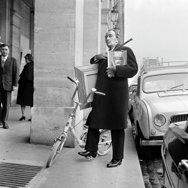 Nghệ sĩ Salvador Dali bên chiếc xe đạp mang những bức tranh mới nhất của mình đến triển lãm Paris. - Sputnik Việt Nam