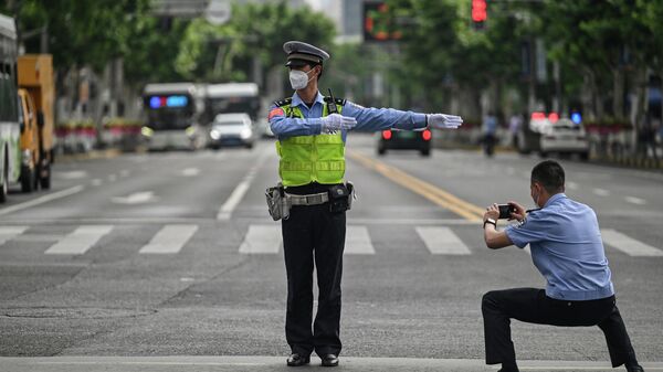 Người sĩ quan chụp ảnh cảnh sát giao thông ở quận Jing'an, Thượng Hải trong ngày 1 tháng 6 năm 2022, sau khi kết thúc phong tỏa chống dịch - Sputnik Việt Nam