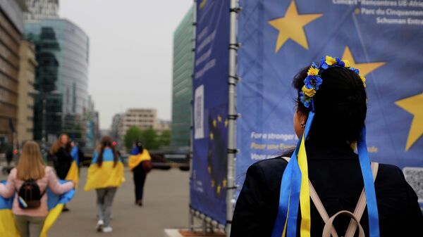 Người biểu tình mang cờ Ukraina khi tham gia một cuộc biểu tình gần trụ sở EU ở Brussels - Sputnik Việt Nam