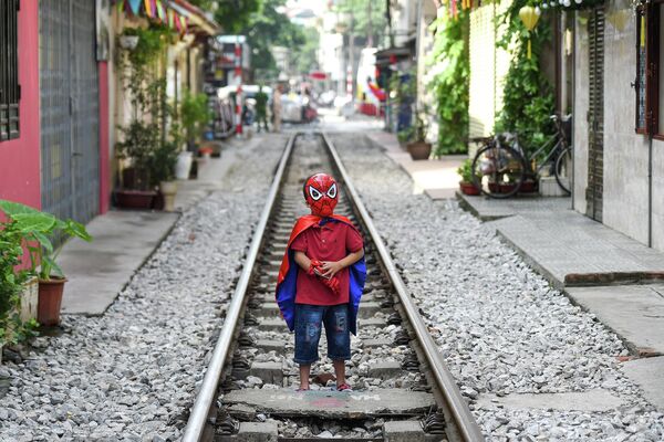 Một nam thanh niên tự sướng gần tàu hỏa chạy qua trong khu vực quán cà phê du lịch trên đường tàu ở Hà Nội. - Sputnik Việt Nam