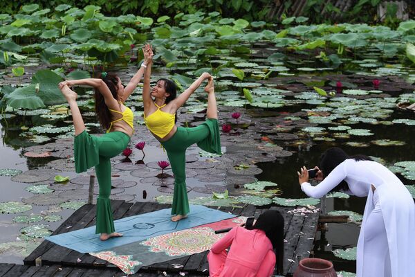 Các cô gái tạo dáng trong buổi chụp ảnh tại đầm sen ở Hồ Tây, Hà Nội. - Sputnik Việt Nam