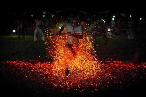 Linh mục Hindu của bộ tộc Rabha chạy chân trần trên than củi như một phần của nghi lễ trong lễ hội Baikho, Ấn Độ. - Sputnik Việt Nam