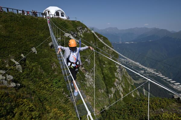 Cô gái trên cầu treo trên đỉnh Roza (độ cao 2 320 mét so với mực nước biển) ở Krasnaya Polyana. - Sputnik Việt Nam