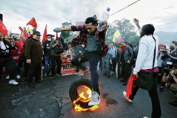 Một học sinh nhảy qua chiếc lốp xe đang cháy trong cuộc biểu tình chống chính phủ ở Quito. - Sputnik Việt Nam