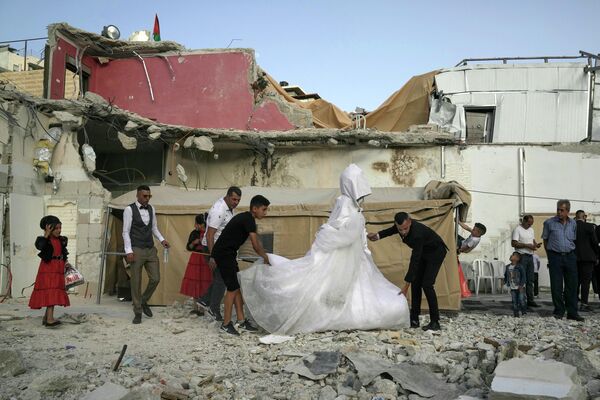 Lễ cưới của người dân Palestine trên đống đổ nát của một ngôi nhà ở đông Jerusalem. - Sputnik Việt Nam