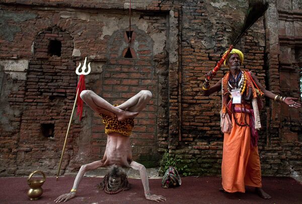 Một Sadhu Ấn Độ hay thánh nhân đạo Hindu, bên trái, tập yoga tại đền Kamahya trong lễ hội Ambubachi ở Gauhati, Ấn Độ. - Sputnik Việt Nam