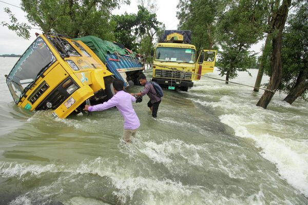 Những chiếc xe tải trên đường phố ngập lụt ở Sunamganj, Bangladesh. - Sputnik Việt Nam